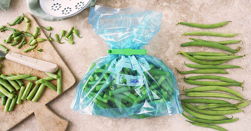 Haricots verts sur une planche à découper et dans un sac congélation Toppits®