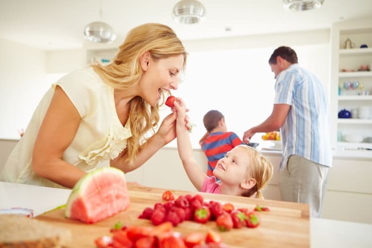 Une mère et son enfant mangeant des fraises fraîches